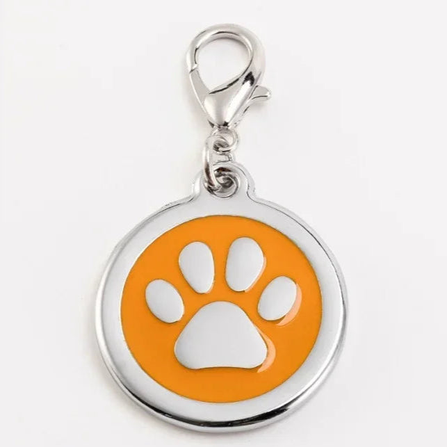 Pet tag with orange circle and white paw print on a white background